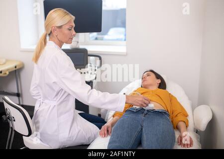 Female ultrasound specialist in white robe looking serious Stock Photo