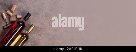 Red and white wine  bottles on stone background. Top view with copy space Stock Photo