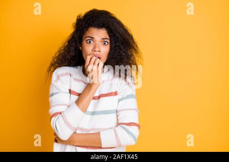 Close-up portrait of her she nice attractive lovely discontent scared worried wavy-haired girl biting nails isolated over bright vivid shine vibrant Stock Photo