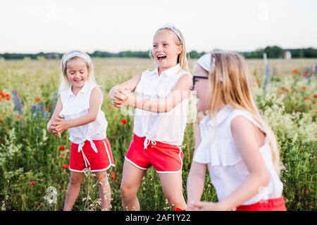 Happy sisters on meadow Stock Photo