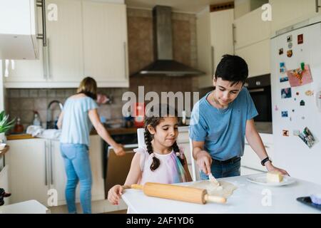Brother and sister baking in kitchen Stock Photo