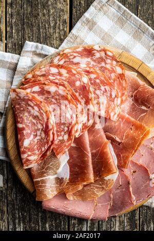 Sliced salami, prosciutto and roast beef on cutting board. Top view. Stock Photo