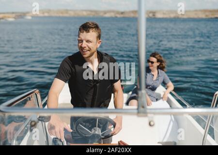 Man steering boat Stock Photo