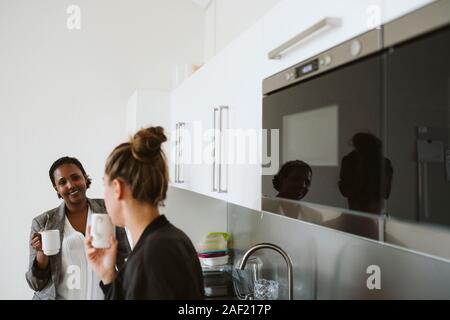 Women having coffee in kitchen Stock Photo