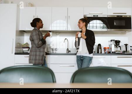 Women having coffee in kitchen Stock Photo