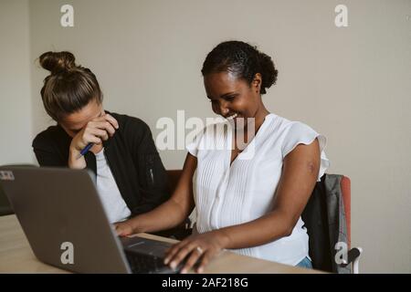 Smiling women using laptop Stock Photo
