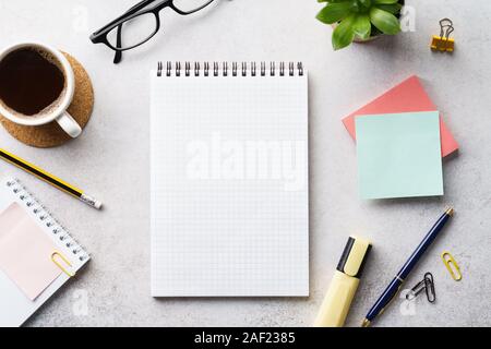 An open empty notebook, stationery and cup of coffee on an office desk. Planning for next year. Overhead shot. Copy space. Stock Photo