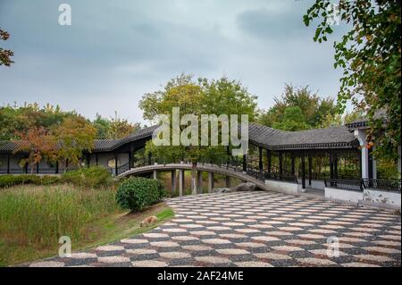 China, Wuxi, Jiangsu Province - covered bridge and walkway in a traditional Chinese Garden in autumn Stock Photo