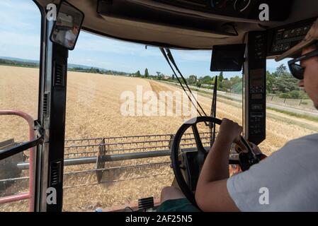 Wheat harvest in summer: combine harvester in a field near Valence in the Drome department (south-eastern France). Combine harvester harvesting wheat Stock Photo