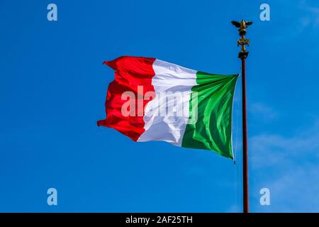 The italian national flag is flying, blue sky in the distance Stock Photo