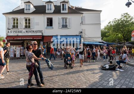 Paris (France) atmosphere in the district of Montmartre. Musicians and couple dancing in the street rue Norvins Stock Photo