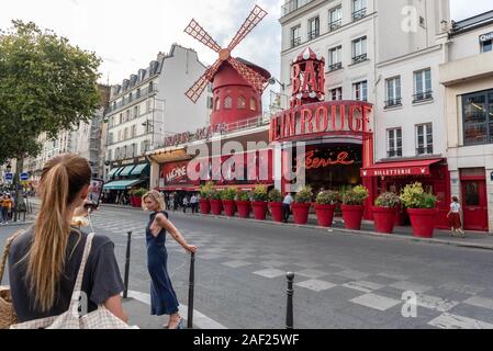 Paris (France): atmosphere in the district of Montmartre, tourists taking pictures in front of the Moulin Rouge cabaret. Stock Photo