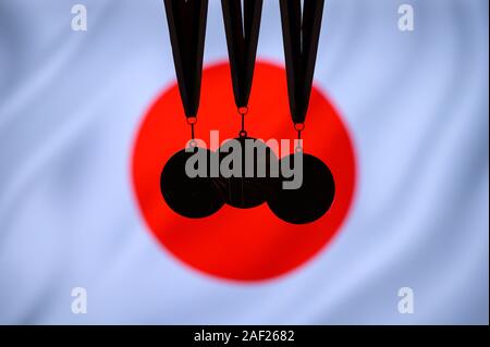 Silhouette of tree medal: Gold, Silver an Bronze. Japan flag in background Stock Photo