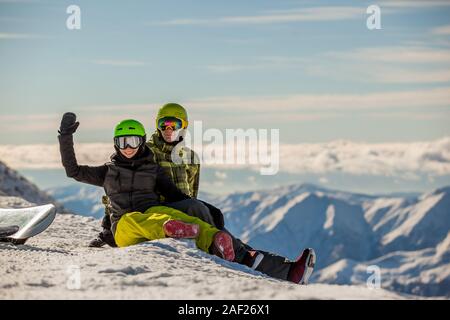 Lucky couple snowboarders in a mountain valley Stock Photo