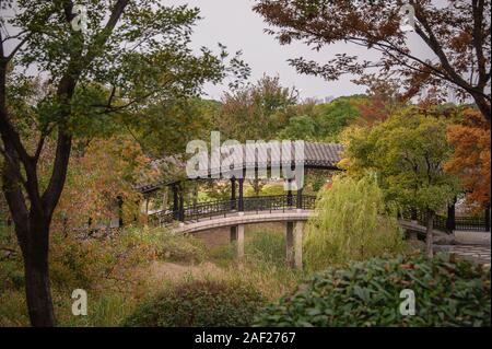 China, Wuxi, Jiangsu Province - covered bridge and walkway in a traditional Chinese Garden in autumn Stock Photo