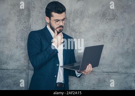 Close-up portrait of his he nice attractive focused concentrated minded bearded guy economist financier holding in hands laptop browsing isolated over Stock Photo