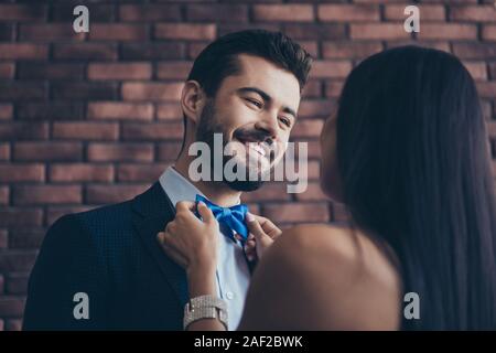 Closeup photo of two affectionate people couple guy looking eyes lady who fixing blue stylish bow tie best pair at prom wear classy formalwear suit Stock Photo