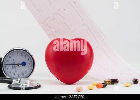 Toy heart and tonometer on the background of a cardiogram. Concept healthcare. Cardiology - care of the heart Stock Photo