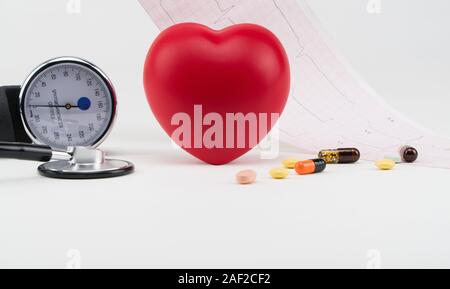 Toy heart and tonometer on the background of a cardiogram. Concept healthcare. Cardiology - care of the heart Stock Photo