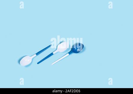So beautiful and so dangerous plastic spoons. Environmental problem of plastic rubbish pollution. Flat lay, top view, copy space. Stock Photo