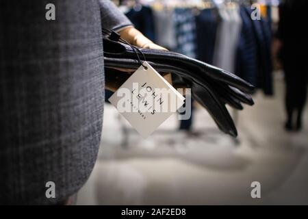 John Lewis and partners fashion department with a ticket hanging from a mannequin in a men's suit holding a pair of stylish leather gloves Stock Photo