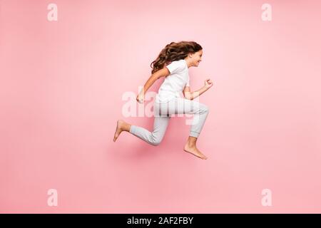 Full length body size side profile photo of cheerful barefoot positive running urgent hurrying preteen wearing t-shirt isolated over pastel color Stock Photo