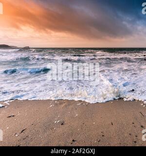Evening light over Little Fistral as the tide comes in on a windy day in Newquay in Cornwall. Stock Photo
