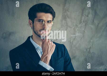 Close up photo of interested thoughtful concentrated focused man touching his stubble wearing eye wear white isolated grey color background Stock Photo