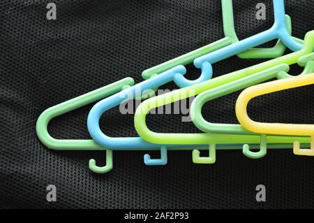 colorful plastic clothes hunger on black fabric Stock Photo