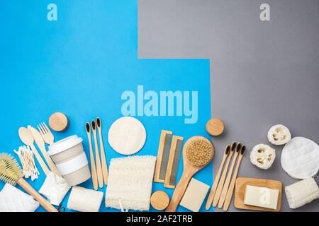 Zero waste eco friendly personal care products wooden brushes, bamboo toothbrushes, luffa, natural soaps, reusable coffee cup on colorful blue grey background, selective focus Stock Photo