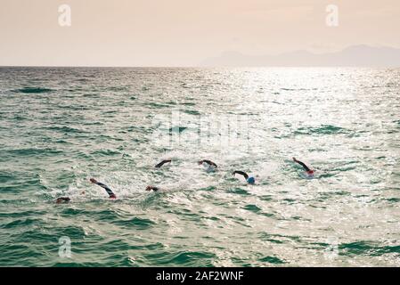 Triathlon swimmers train in open water in the sea. Mallorca, Spain Stock Photo