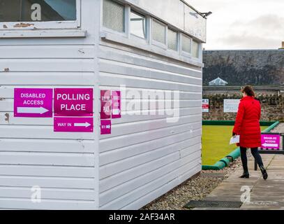 Gullane Bowling Club, East Lothian, Scotland, United Kingdom, 12th December 2019. UK election: a woman wearing a read coat goes into the local polling place Stock Photo