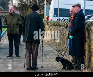 Gullane Bowling Club, East Lothian, Scotland, United Kingdom, 12th December 2019. UK election: voters going into the local polling place with local activists and a man holding a dog on a lead Stock Photo