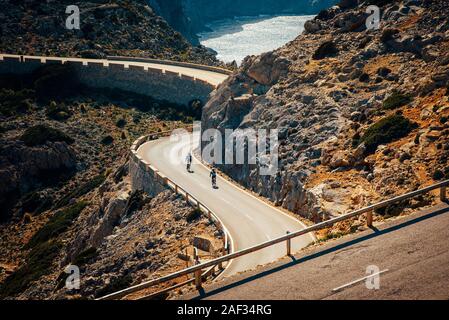 Road bikers on the road on Balearic Islands. Sea in Background. Cap de Formentor. Mallorca, Majorca, Spain Stock Photo