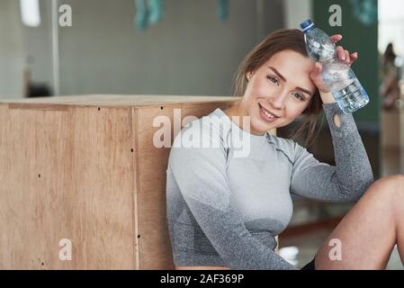 Looking at the camera. Sportive young woman have fitness day in the gym at morning time Stock Photo