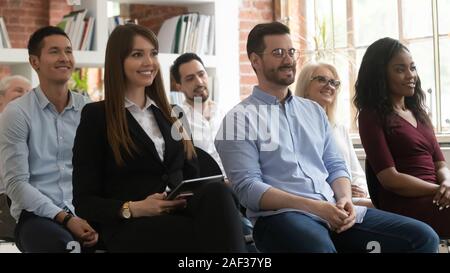 Diverse entrepreneurs sitting on chairs take part in seminar Stock Photo