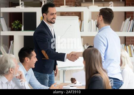 Multi racial businessmen shaking hands closing deal Stock Photo