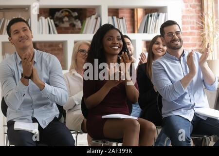 Diverse entrepreneurs seminar participants clap hands expressing gratitude for speech Stock Photo