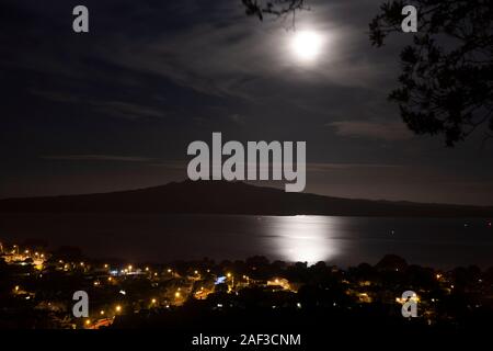 Cone-shaped Rangitoto Island in the Hauraki Gulf, New Zealand. Viewed from Mount Victoria (Takarunga), Devonport across Cheltenham Beach at night. Stock Photo