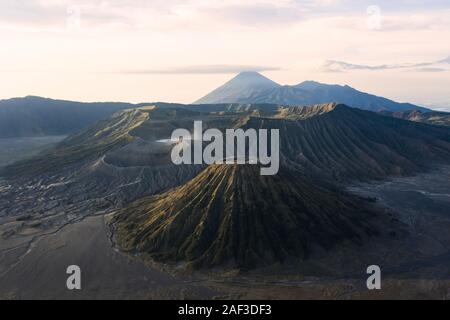 View from above, stunning aerial view of the Mount Batok and the Mount Bromo illuminated at sunset. Mount Bromo is an active volcano in East Java. Stock Photo