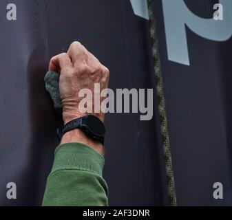 Hand reaches into the climbing knob of a climbing wall, concept photo for upwards Stock Photo