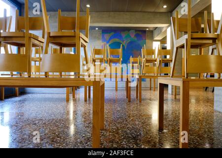 School type cafeteria eating area with all chairs raised on tables for floor cleaning Stock Photo