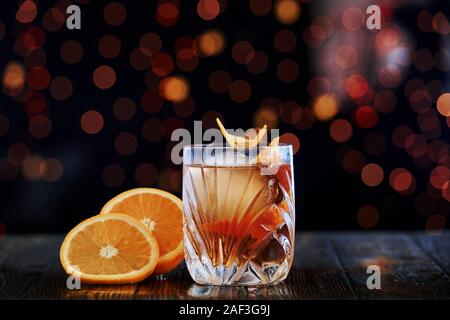 With big ice cube. Cocktail is ready. On the wooden table in the night club. Nice lighting Stock Photo