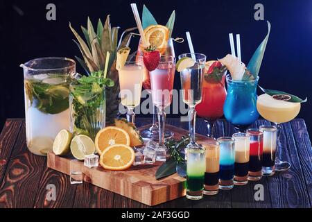 Set of many different cocktails. Drinks is ready. On the wooden table in the night club. Nice lighting Stock Photo