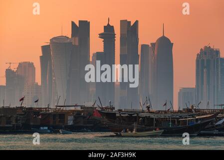 The traditional dhow boats of the Qataris stand against the modern skyline of Doha, Qatar. Stock Photo