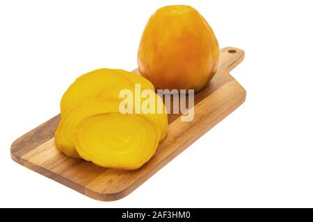 Cooked yellow beetroots on a wooden cutting board - white background Stock Photo