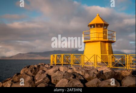 Beautiful yellow lighthouse in Reykjavik Bay during the evening Stock Photo