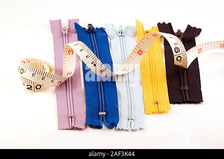 Zippers and measuring tape isolated on white background Stock Photo