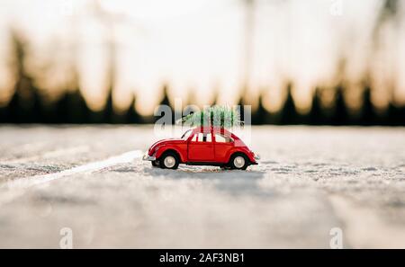 mini beetle car with Christmas tree on top parked in the snow Stock Photo