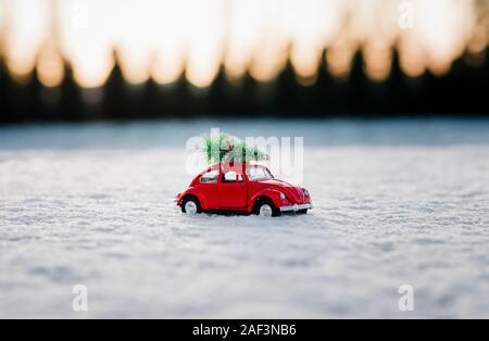 beetle car with a Christmas tree on top parked in the snow Stock Photo